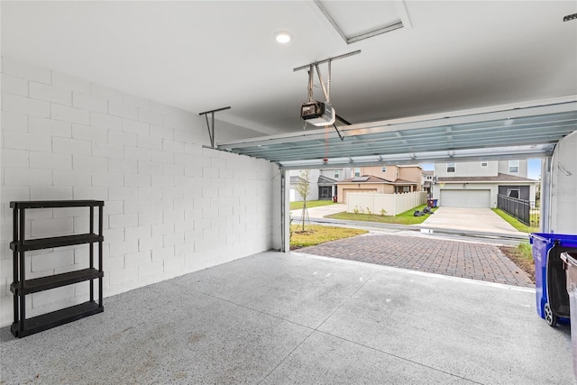 garage with a garage door opener and concrete block wall