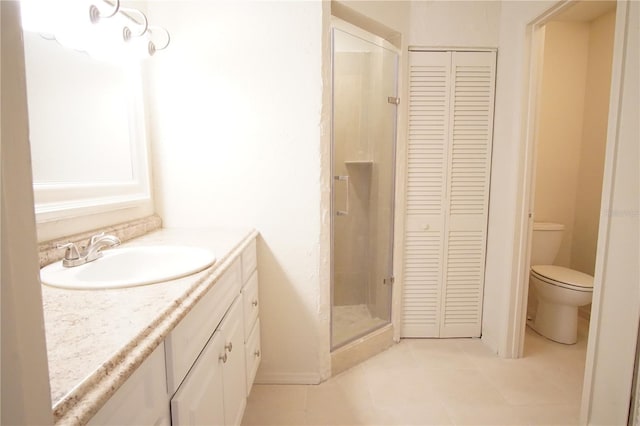 bathroom featuring tile patterned floors, a closet, vanity, and a shower stall