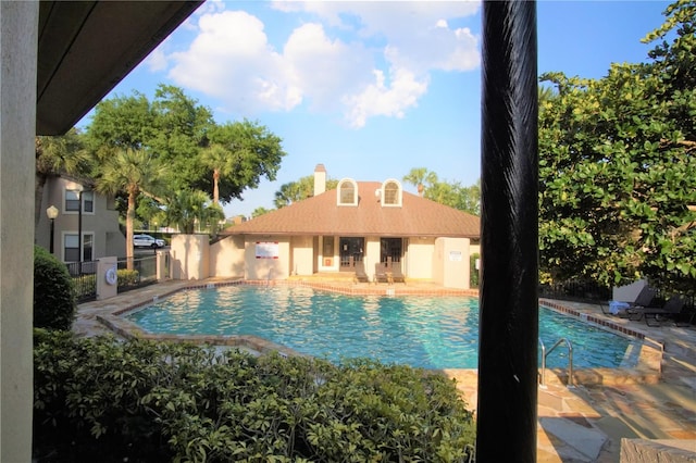 pool with a patio area and fence