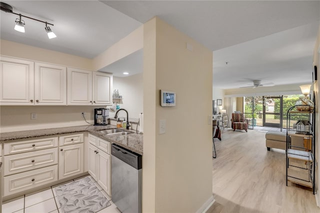445 Bouchelle Dr Unit 104, New Smyrna Beach, FL 32169 - kitchen featuring stainless steel dishwasher, light stone counters, open floor plan, white cabinetry, and ceiling fan
