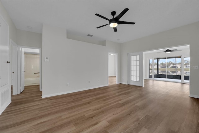 unfurnished living room with baseboards, wood finished floors, and a ceiling fan