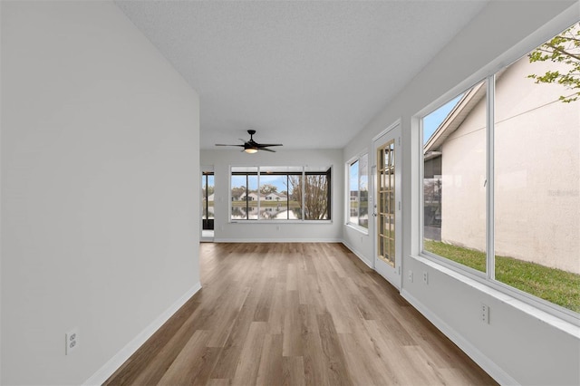 unfurnished sunroom with a ceiling fan