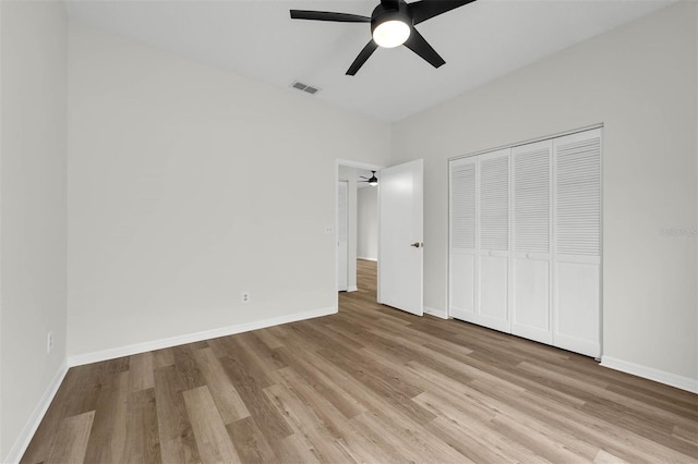 unfurnished bedroom with visible vents, baseboards, a closet, and wood finished floors