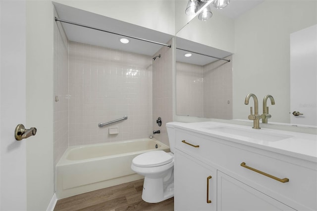 bathroom with vanity, washtub / shower combination, toilet, and wood finished floors