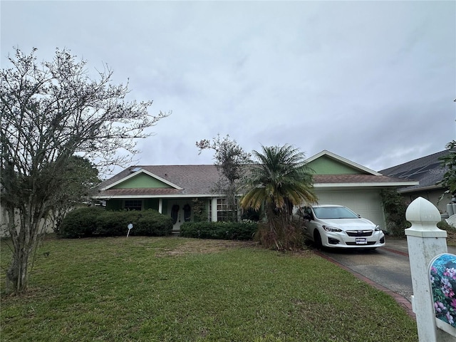 ranch-style house with aphalt driveway, a front lawn, and an attached garage