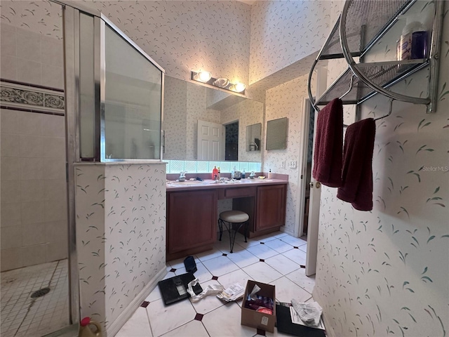 bathroom with double vanity, a stall shower, a sink, and wallpapered walls