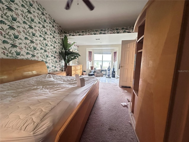 bedroom with visible vents, carpet, an accent wall, and wallpapered walls