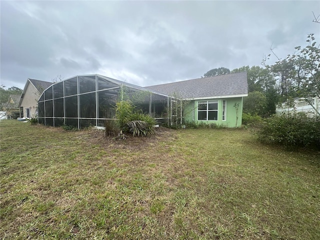 rear view of property featuring a lanai and a yard