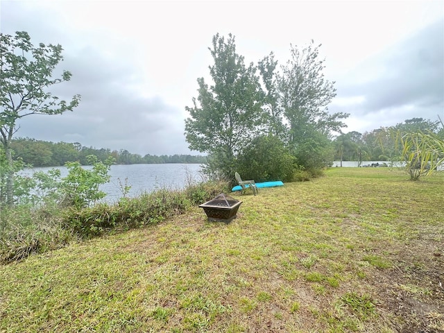 view of yard featuring an outdoor fire pit and a water view