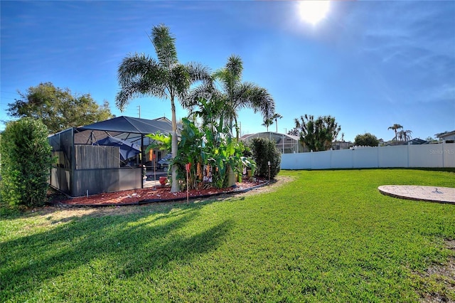 view of yard with a lanai and fence