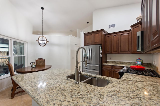 kitchen featuring visible vents, light stone countertops, appliances with stainless steel finishes, high vaulted ceiling, and a sink