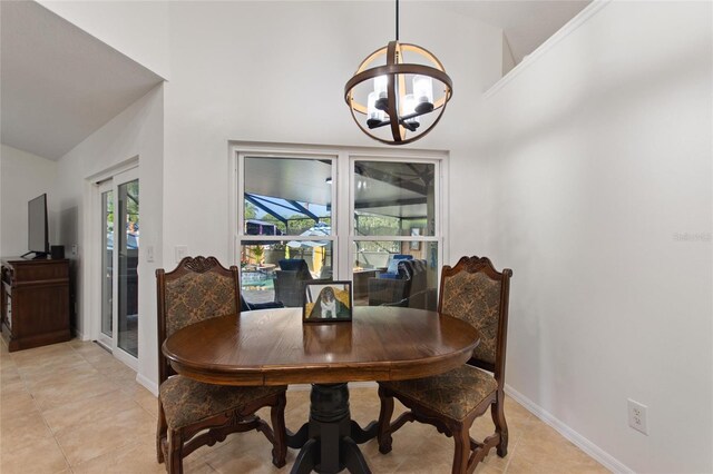 dining space featuring a chandelier, light tile patterned floors, high vaulted ceiling, and baseboards