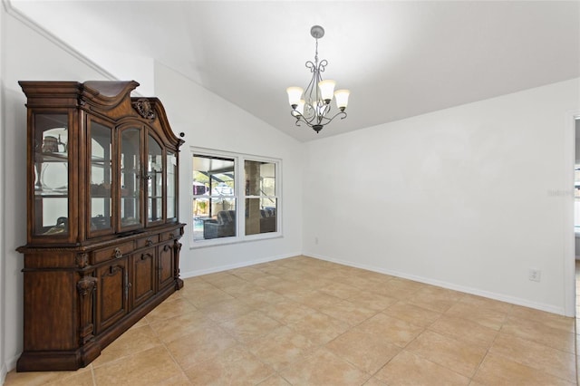 dining space featuring an inviting chandelier, baseboards, and lofted ceiling