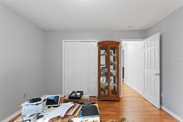 home office featuring baseboards and light wood finished floors