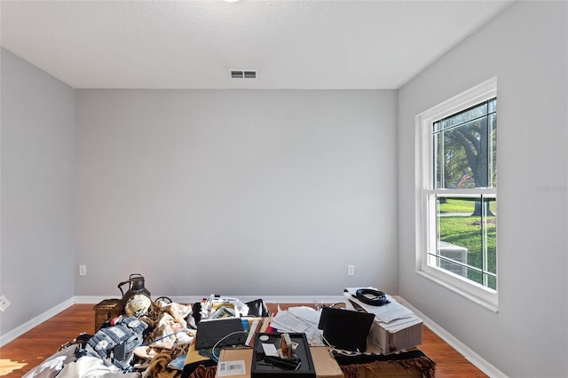 bedroom with visible vents, baseboards, and wood finished floors