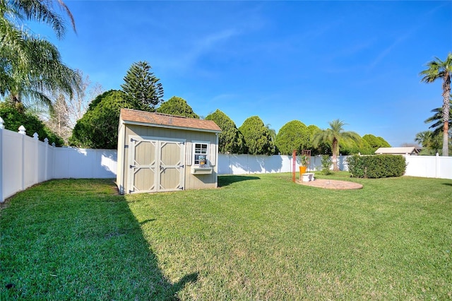 view of yard with an outbuilding, a storage unit, a fenced backyard, and a water view