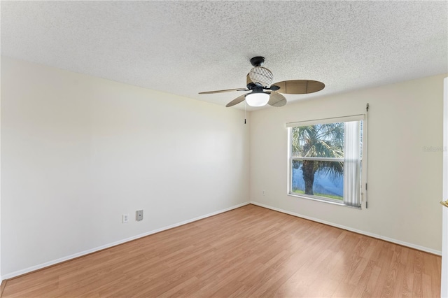 empty room with ceiling fan, baseboards, light wood finished floors, and a textured ceiling