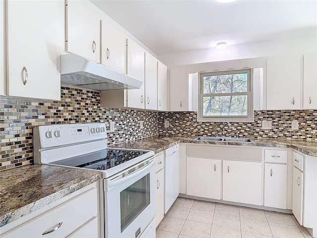 kitchen with under cabinet range hood, white appliances, tasteful backsplash, and a sink