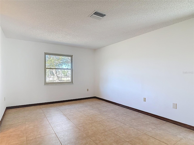 unfurnished room featuring visible vents, a textured ceiling, and baseboards