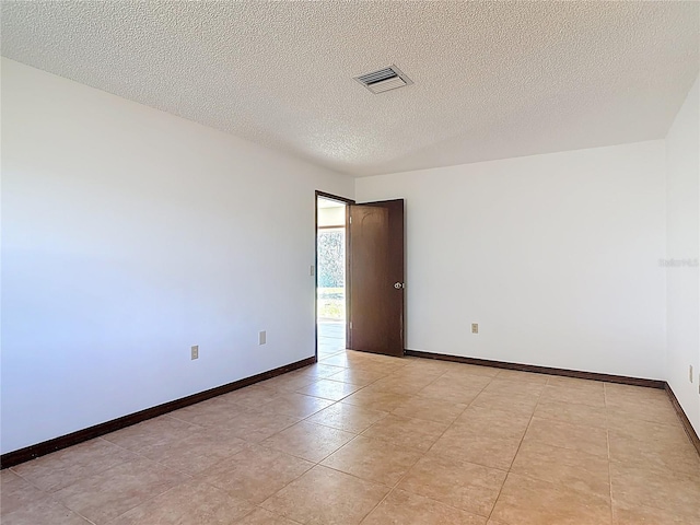 spare room with visible vents, a textured ceiling, and baseboards