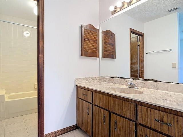 bathroom with tile patterned flooring, visible vents, a textured ceiling, and vanity