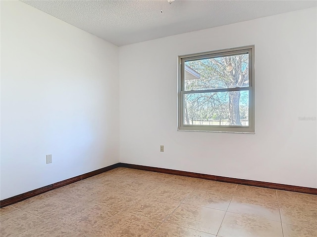 unfurnished room featuring baseboards and a textured ceiling