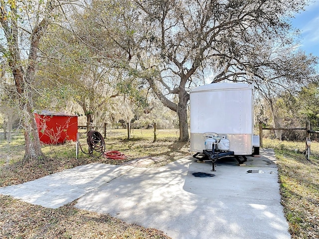 view of patio featuring an outbuilding, fence, and a shed