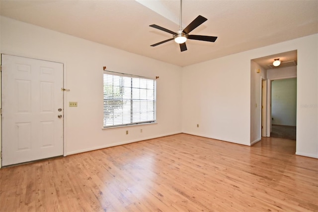 empty room featuring ceiling fan, baseboards, light wood-style flooring, and vaulted ceiling