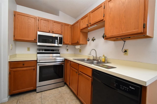 kitchen featuring a sink, stainless steel appliances, a textured ceiling, and light countertops