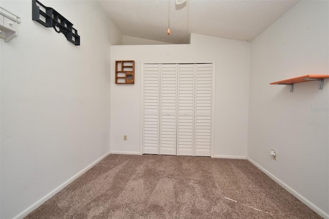 interior space featuring baseboards, a textured ceiling, and lofted ceiling