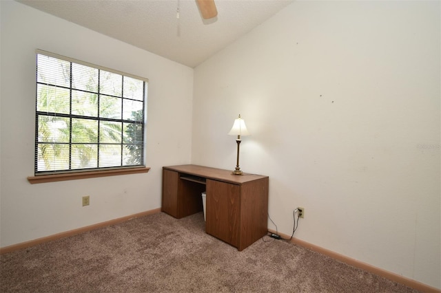 unfurnished office featuring lofted ceiling, light colored carpet, baseboards, and ceiling fan