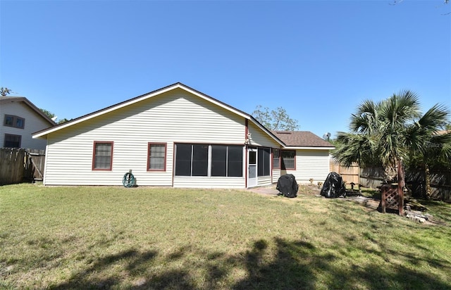 back of house featuring a lawn and fence