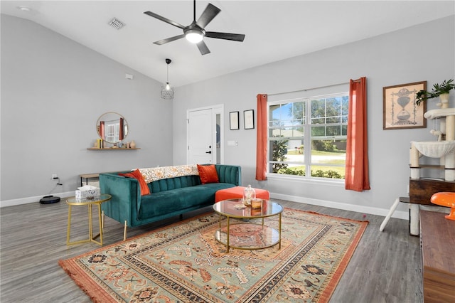 living room featuring lofted ceiling, wood finished floors, baseboards, and visible vents