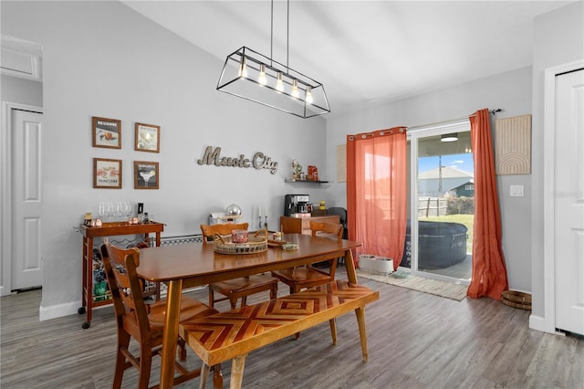 dining space with baseboards and wood finished floors