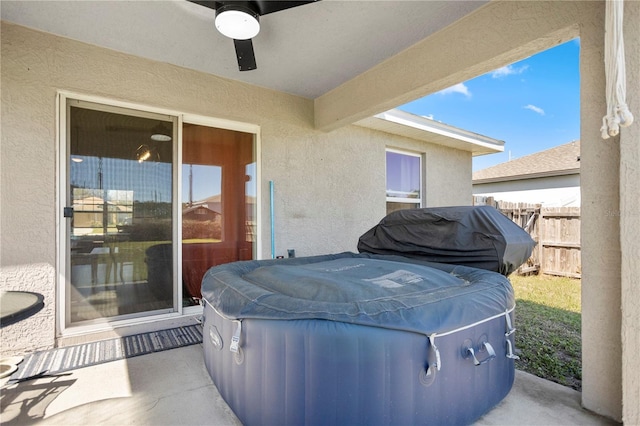 view of patio / terrace with a ceiling fan, area for grilling, fence, and a hot tub