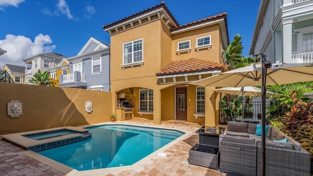 back of house with fence, stucco siding, a tile roof, a patio area, and an outdoor hangout area