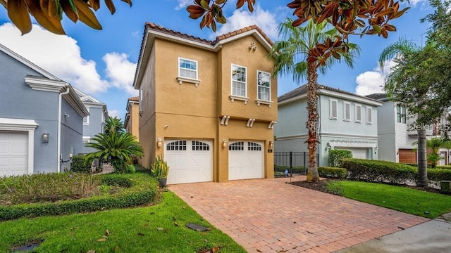 view of front of house with stucco siding, decorative driveway, a garage, and a tile roof