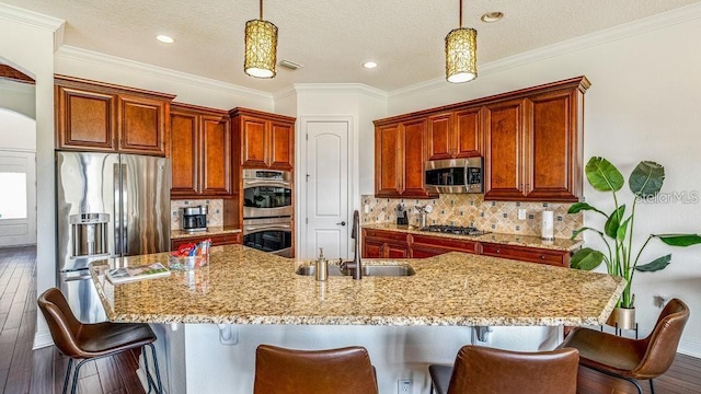 kitchen featuring a sink, stainless steel appliances, decorative backsplash, dark wood-style flooring, and hanging light fixtures