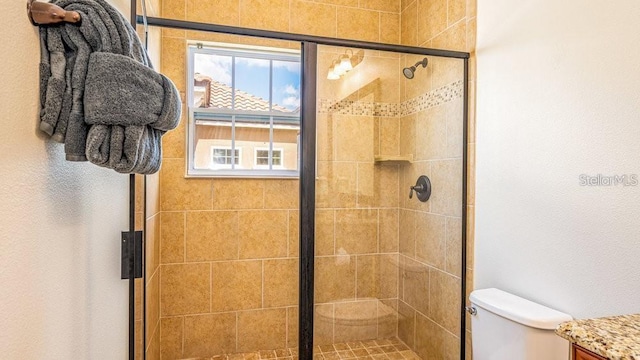 full bathroom with a stall shower and toilet