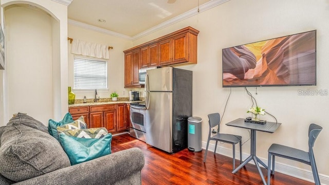 kitchen with a sink, dark wood-type flooring, appliances with stainless steel finishes, crown molding, and brown cabinets