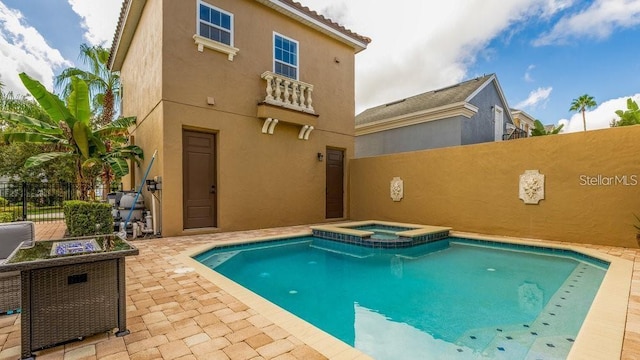 view of swimming pool with a patio area, a pool with connected hot tub, and fence