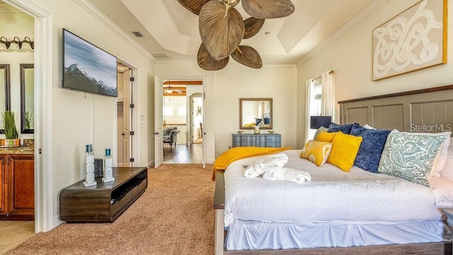 carpeted bedroom with crown molding, visible vents, and a tray ceiling