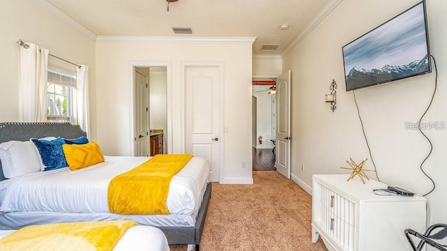 bedroom with visible vents, ensuite bathroom, crown molding, baseboards, and light colored carpet