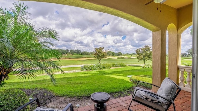 exterior space with golf course view and a ceiling fan