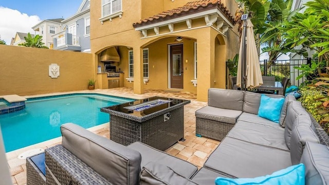 view of swimming pool with a patio, fence, exterior kitchen, area for grilling, and an outdoor living space with a fire pit