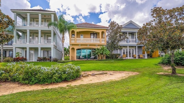 exterior space with a tile roof, a lawn, french doors, and stucco siding