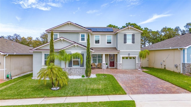 craftsman inspired home featuring stone siding, decorative driveway, and a front lawn