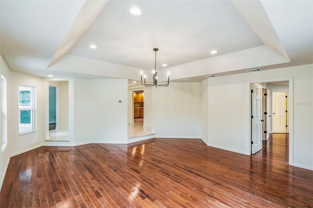 unfurnished room with hardwood / wood-style floors, a raised ceiling, and recessed lighting