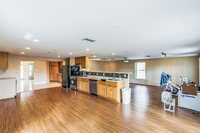 kitchen featuring visible vents, open floor plan, wood finished floors, stainless steel appliances, and a sink