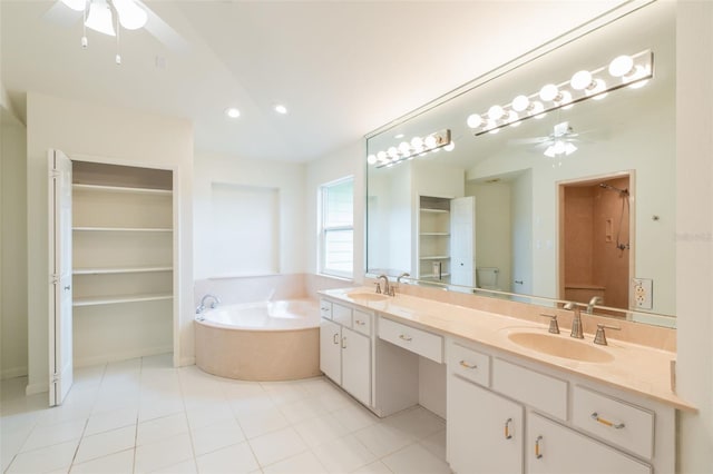 full bathroom with ceiling fan, a garden tub, double vanity, and a sink